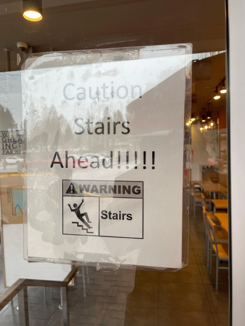 The sign reads 'caution stairs ahead' with a suspicious number of exclamation marks
